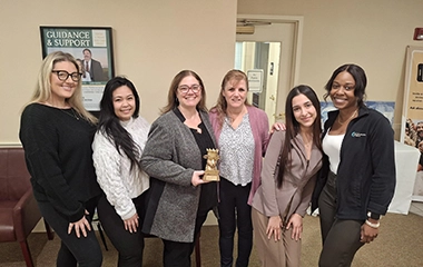 Employees holding up an award