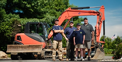 A family standing in front of an excavator