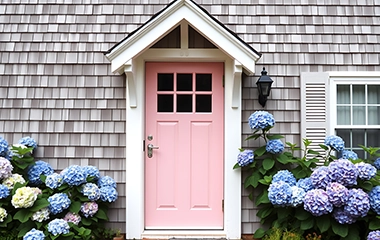 A pink front door on a cape cod home