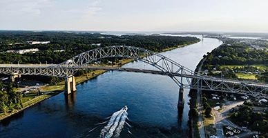 A bridge over the water with a boat going under it