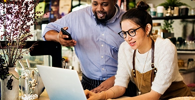 Two store owners working on a laptop