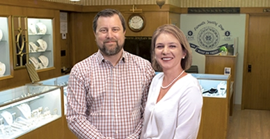 Stephen and Neda Sullivan of Falmouth Jewelry Shop stand together inside store.