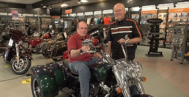Cape Cod Harley Davidson owners sit on bike in showroom