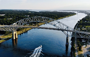 A bridge going over the water with a speedboat below it