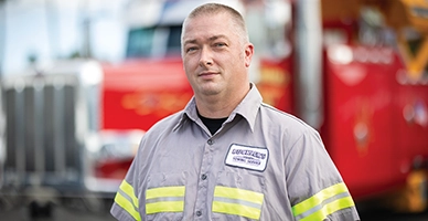 A trucker standing in front of his truck