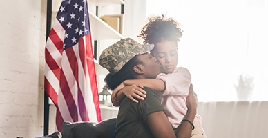 A soldier kissing her daughter on the cheek
