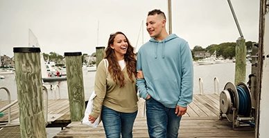 A couple walking down a dock at the beach