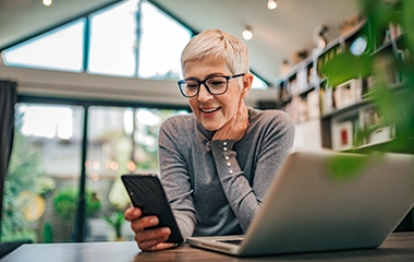 A woman smiling and using her mobile phone
