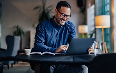 A man smiling on his laptop