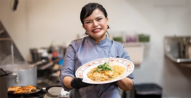 A chef holding up a plate of food