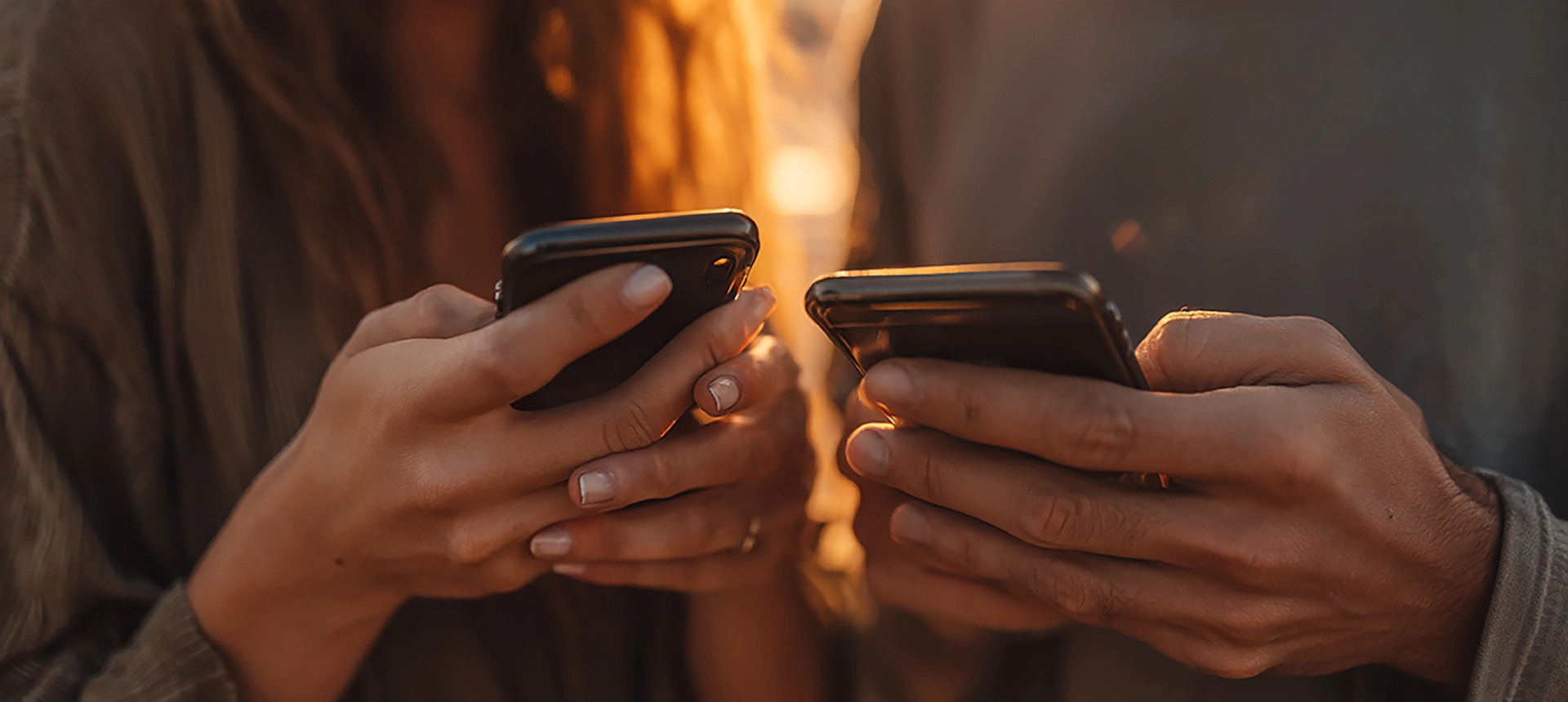A close up of two people using their mobile phones