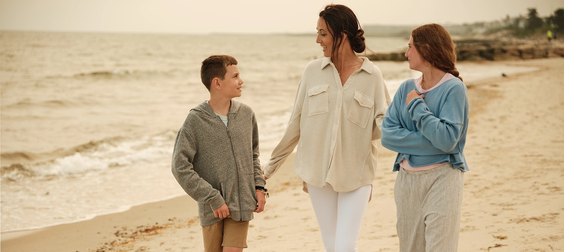 A family laughing and walking on the beach
