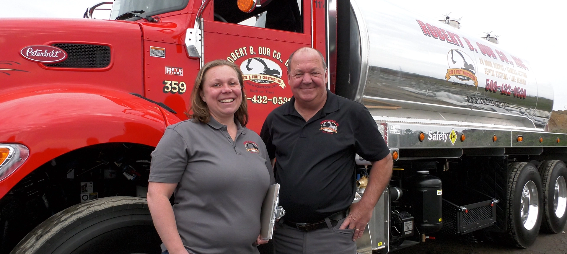 Small business owners posing in front of a truck