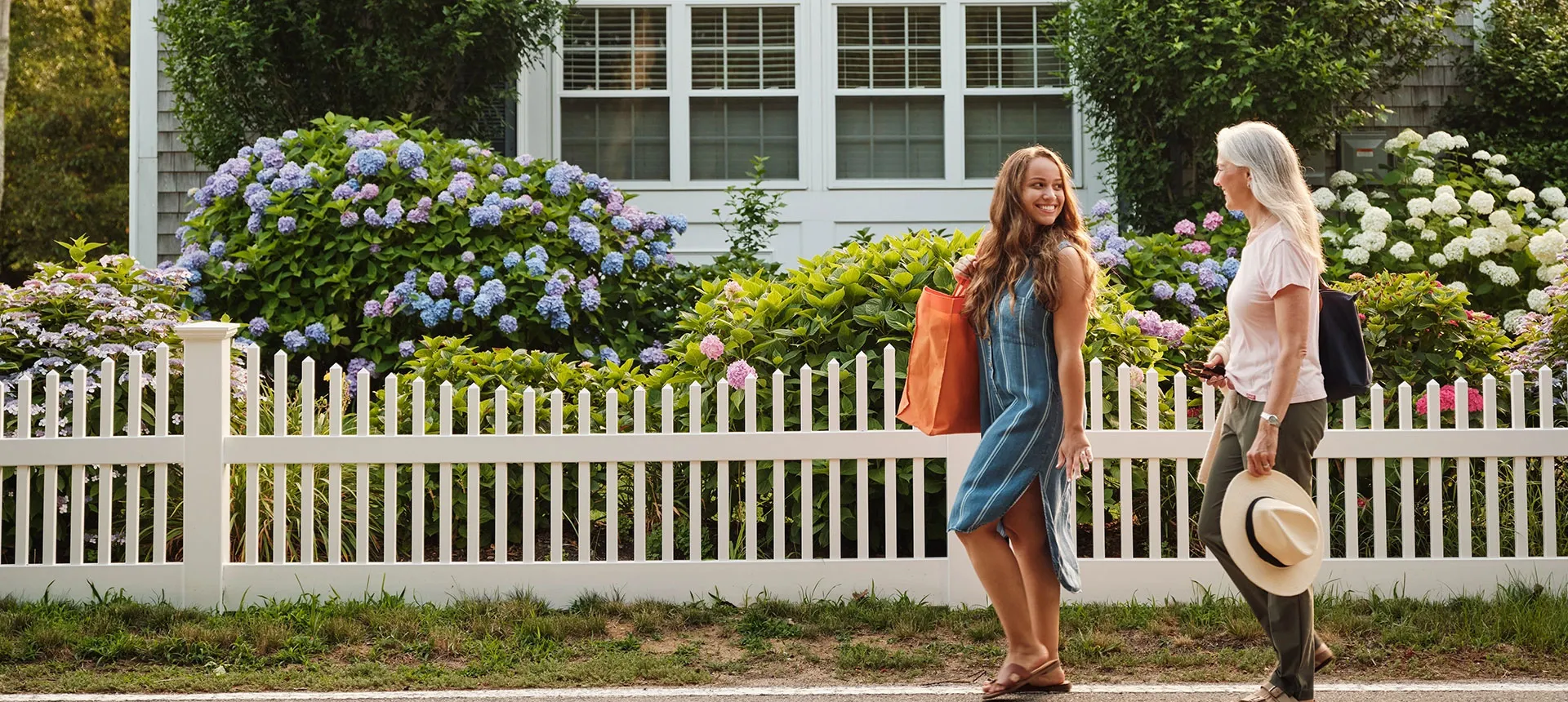 Two women walking in front of a beach house