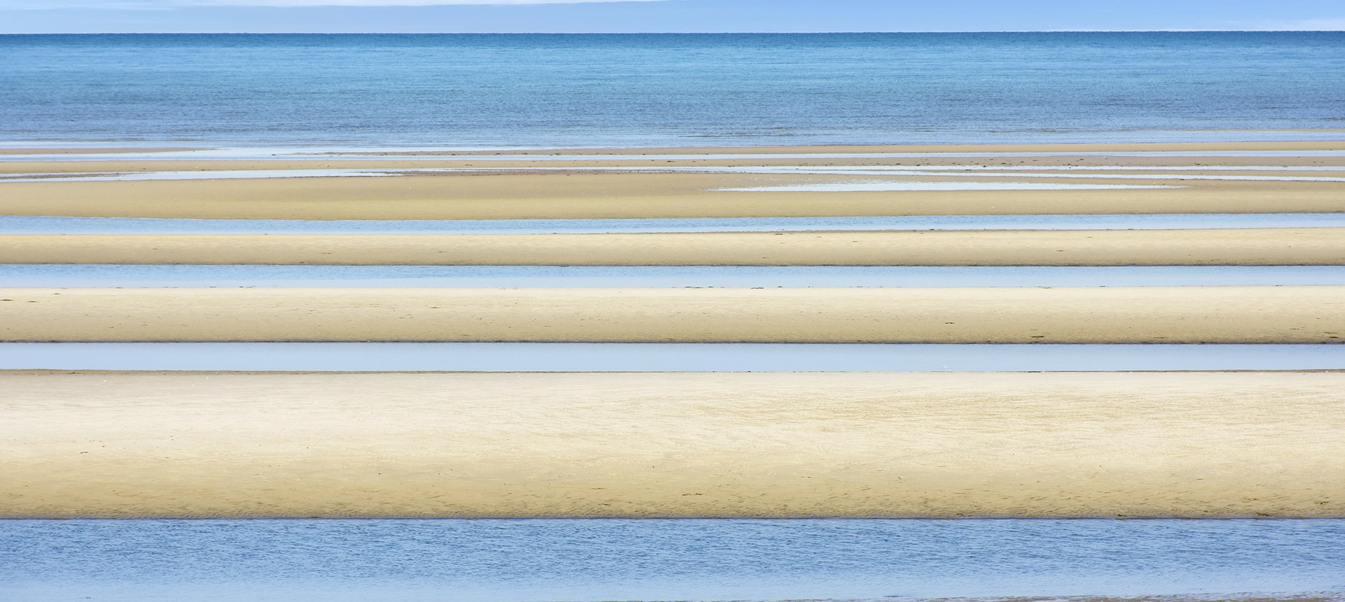 Sand Stripes - Low tide at beach revealing sand and water striping