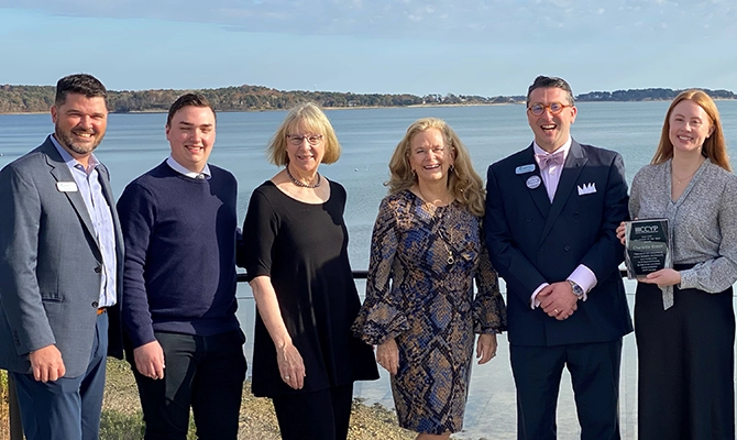 Leadership standing on the beach posing for a picture
