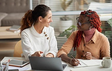 Two people having a conversation and taking notes
