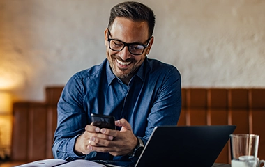 A man smiling and looking at his phone