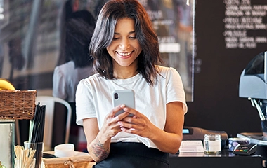A barista on her phone behind the counter