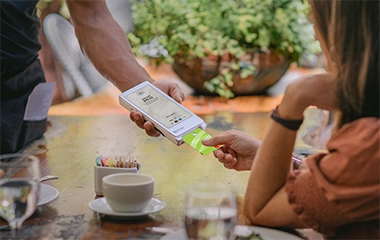 A customer paying for her coffee with a Clover machine