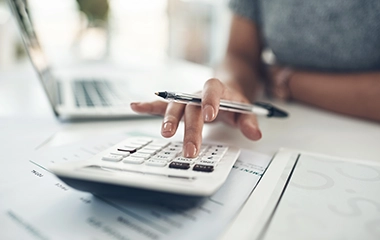 A woman typing on a calculator