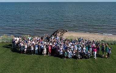 A birds eye view of Cape and Coast bank employees posing for a picture at the beach