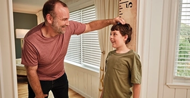A father measuring his sons height