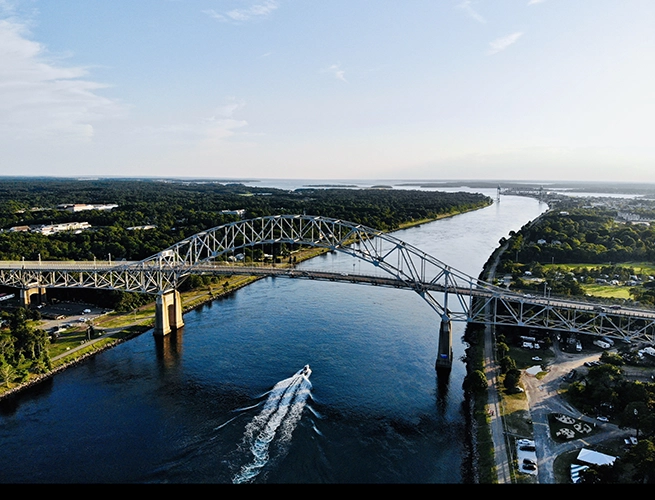 A bridge going over water with a speed boat below it