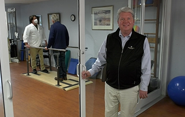 An employee standing in front of a physical therapy office