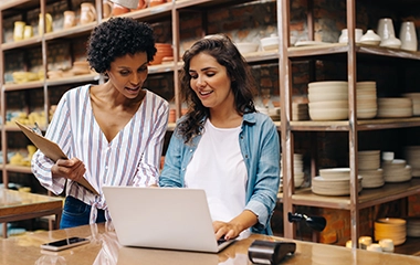 Two small business owners looking at a laptop