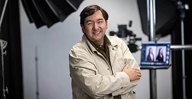 A small business owner with camera equipment in the background